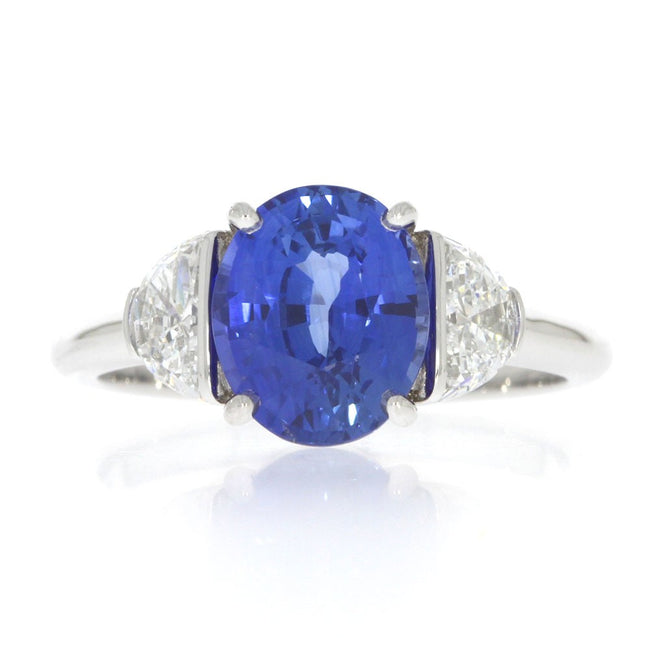 18 Karat White Gold And Oval Blue Sapphire And Half Moons Brilliant Diamonds Three Stone Ring