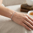 A persons wrist wearing a single diamond bracelet 